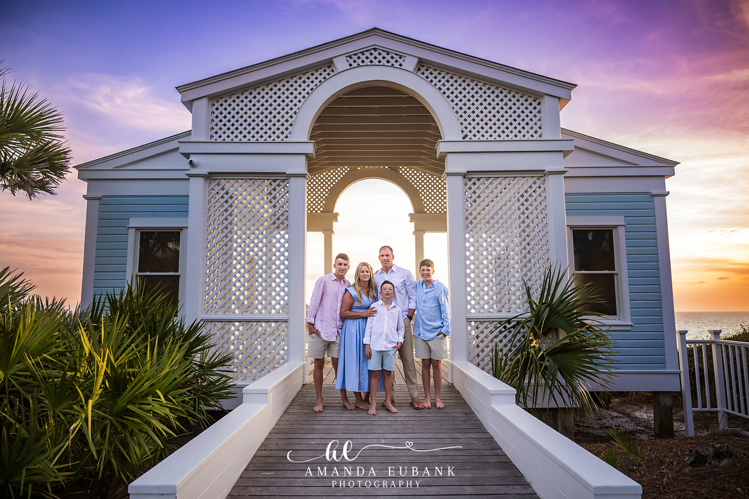 Family together smiling on the beach at a golden sunset in Seaside Florida