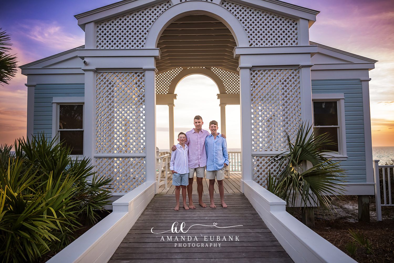 Family posing together on the beach at a colorful sunset in Seaside Florida