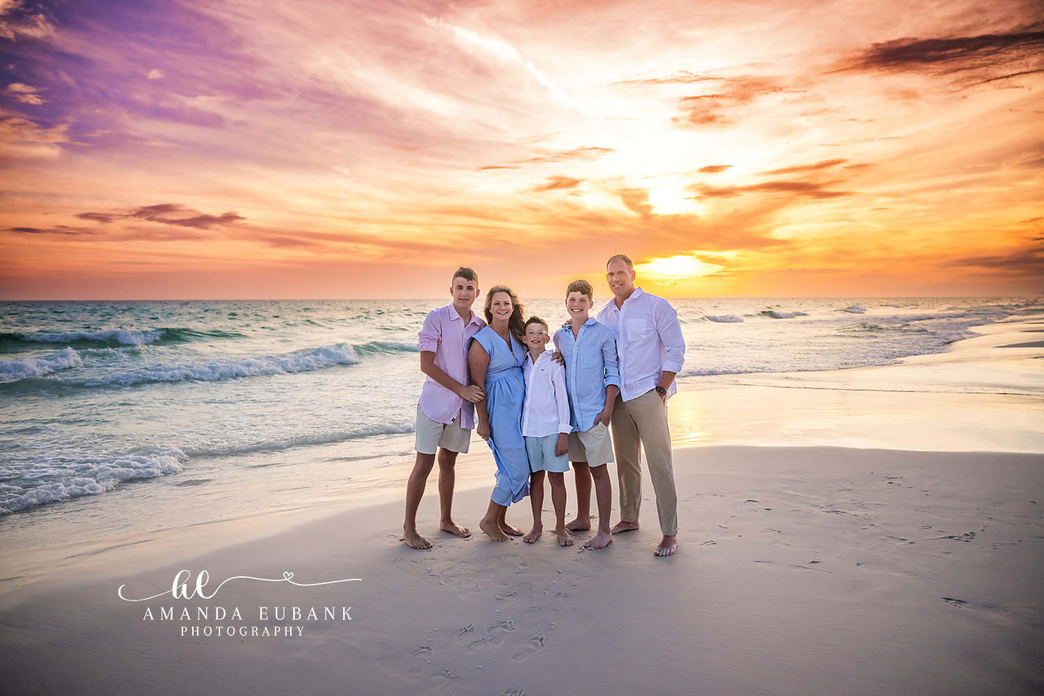 Family together smiling on the beach at a golden sunset in Seaside Florida