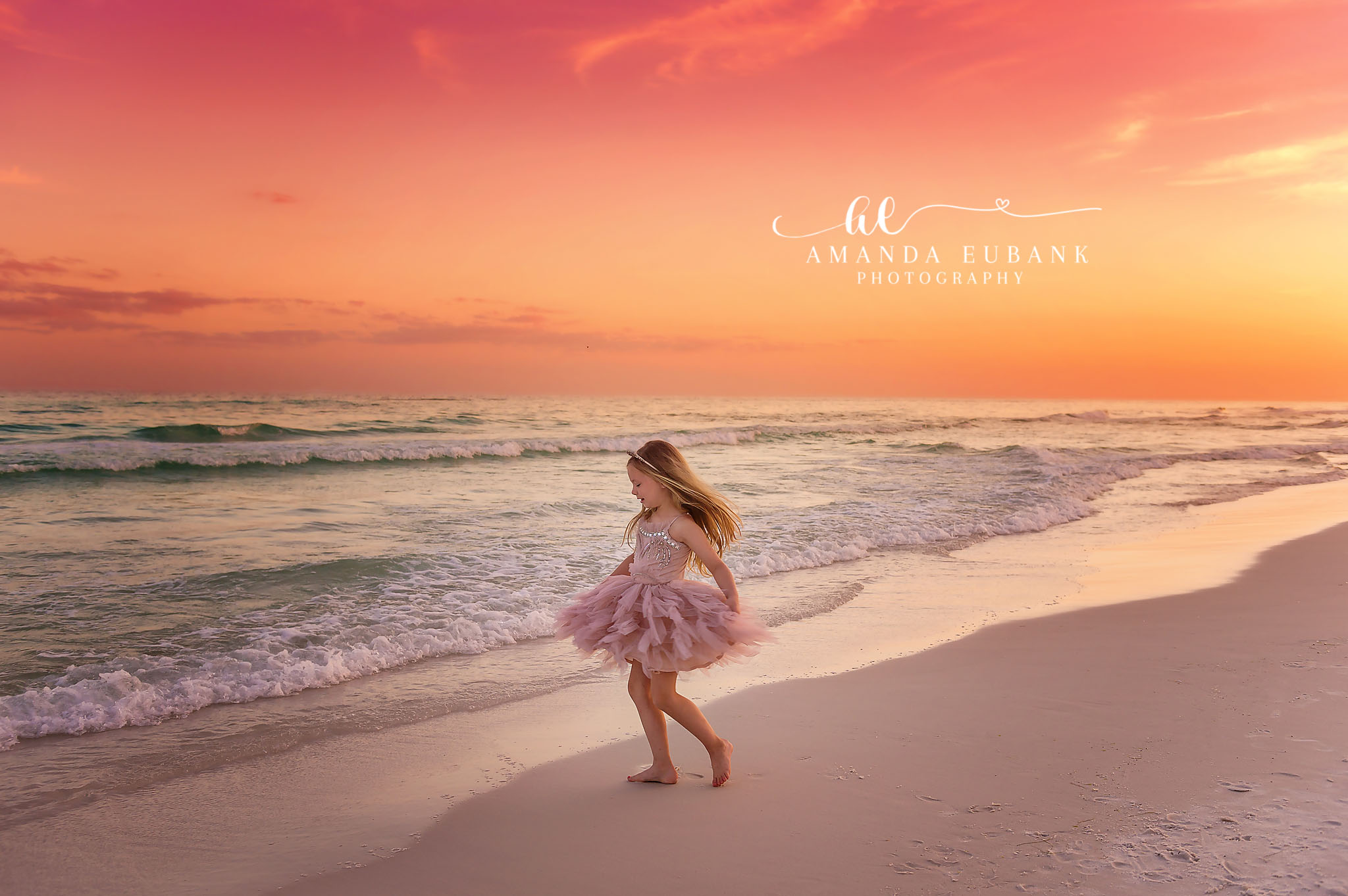 Seaside family photographer captures little girl in pink tutu walking on beach at coral sunset