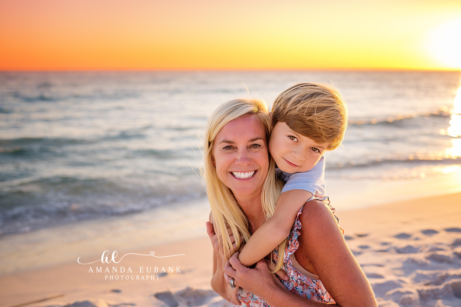 Mom hugging and holding her young son on the beach at a golden sunset in Seaside Florida