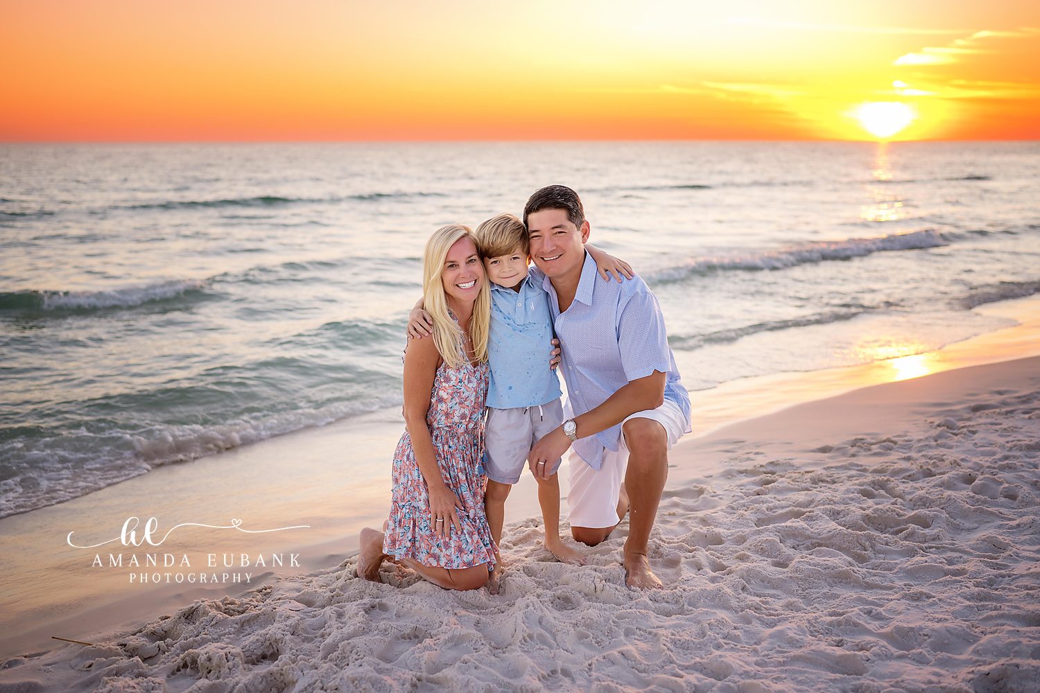 Family posing together on the beach with a golden sunset sky in Seaside Florida