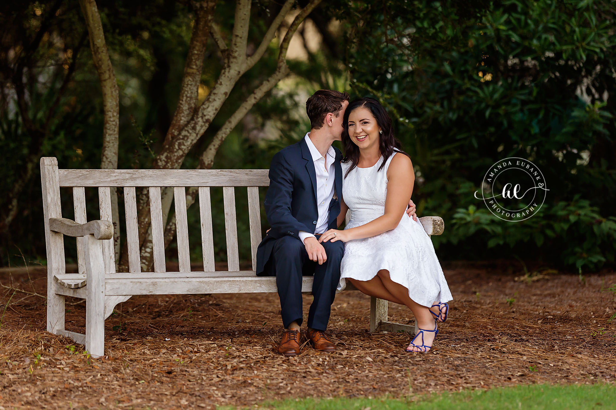 Seaside engagement photographer captures couple sharing a quiet moment on a garden bench