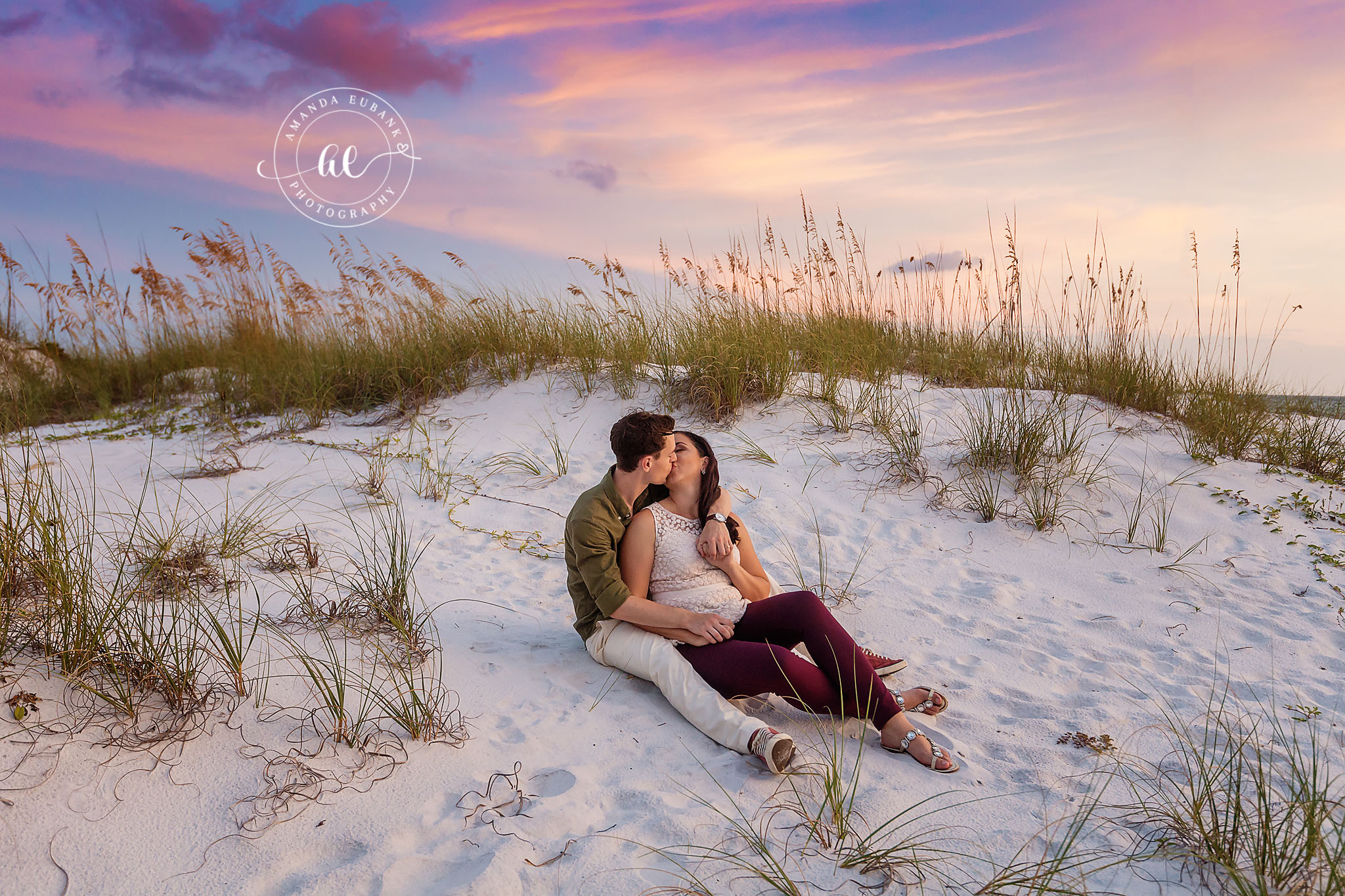 Sand Dune Engagement Photo Session in Seaside Florida at Sunset Seaside engagement photographer captures couple kissing on sand dunes among sea oats at sunset