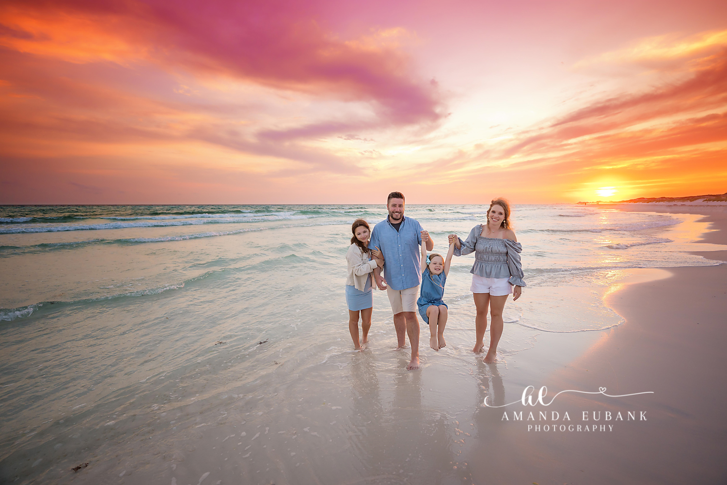 Seaside family photographer capturing a sunset beach portrait with warm golden light over the Gulf of Mexico