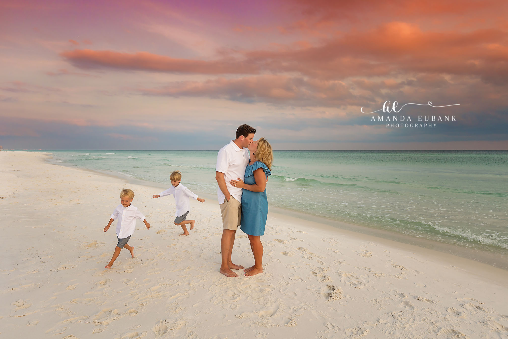 Family wearing coordinated cream and sand outfits during a Seaside beach family photography session at sunset