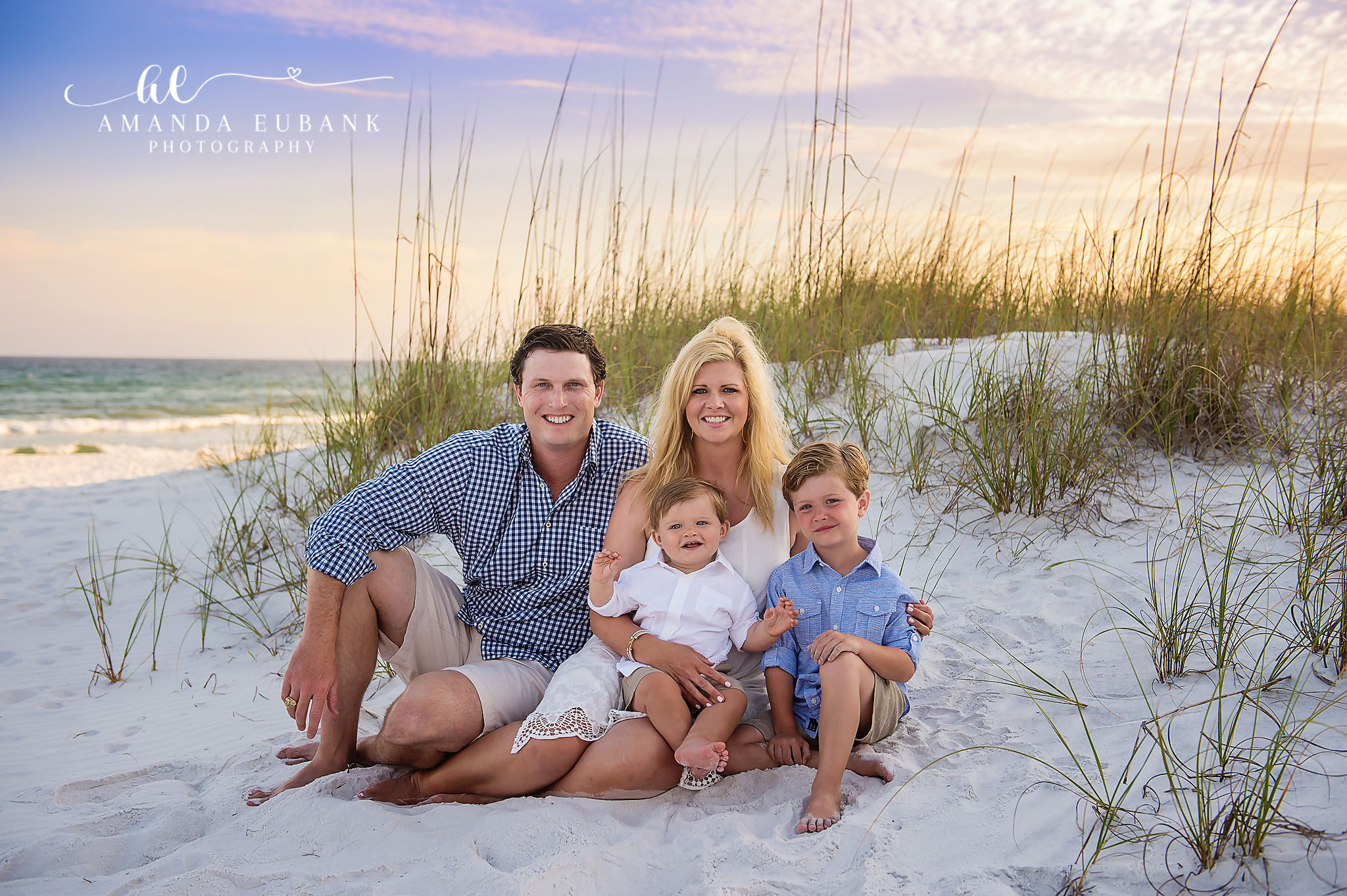 Seaside family photographer captures family of four in dunes at peach sunset