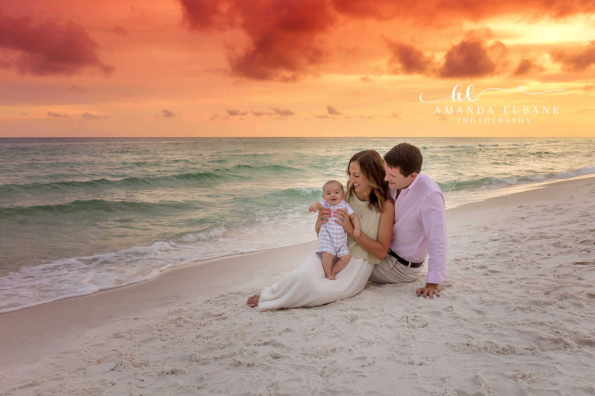 Family of Three Beach Portrait at Fiery Sunset in Seaside Florida Seaside family photographer captures parents with baby boy on beach at fiery orange sunset