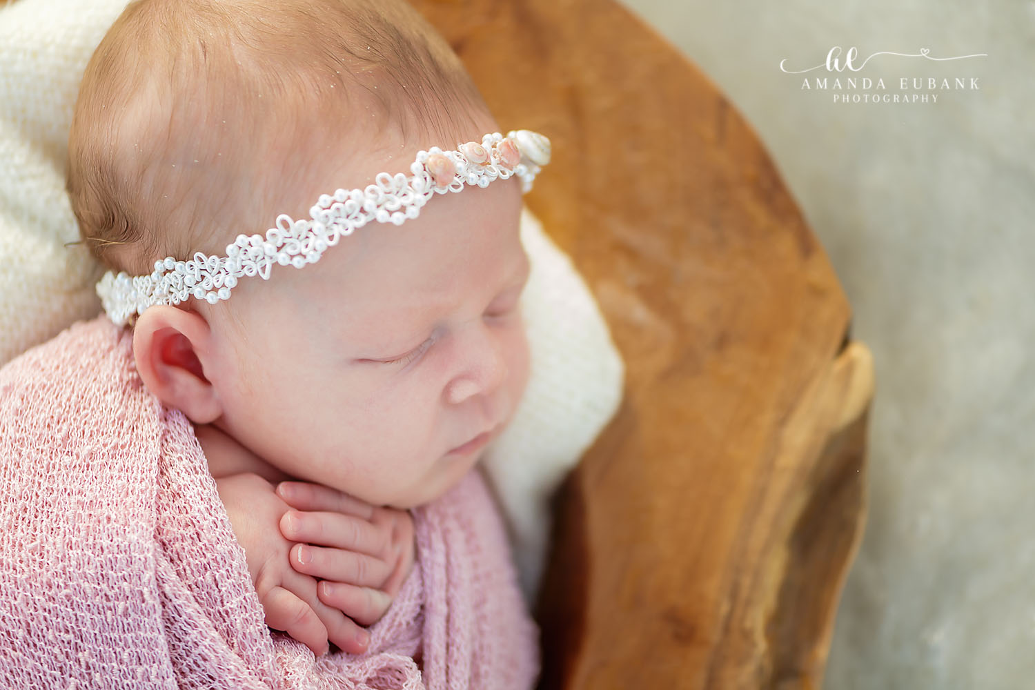 Newborn Photographer in Seaside FL | Coastal Newborn Session Newborn baby wrapped in pink knit sleeping peacefully on the sand during a Seaside FL beach newborn session