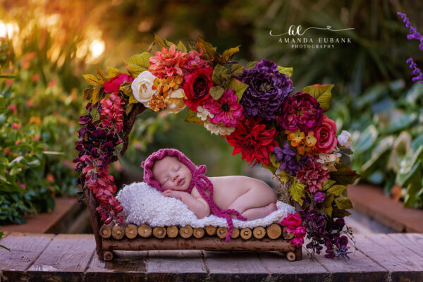 Seaside FL newborn photographer captures angelic sleeping baby at a colorful coastal sunset portrait session