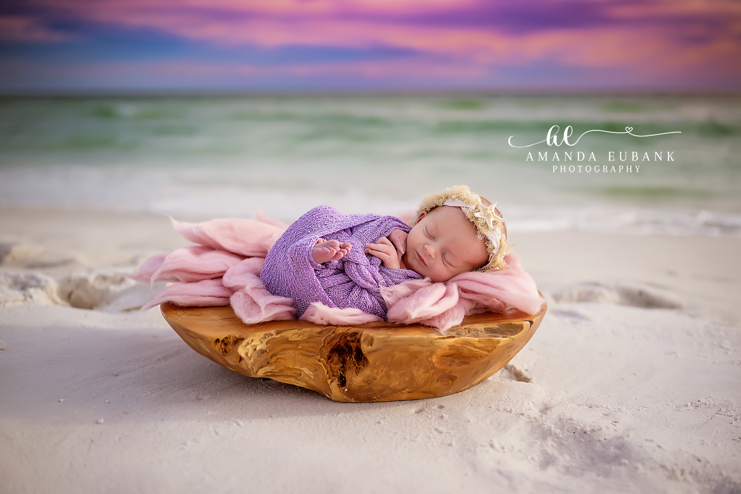 Newborn baby wrapped in pink knit sleeping peacefully on the sand during a Seaside FL beach newborn session