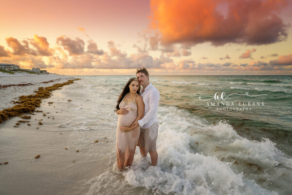 Expecting mother and partner embracing during a romantic Seaside Florida beach maternity portrait