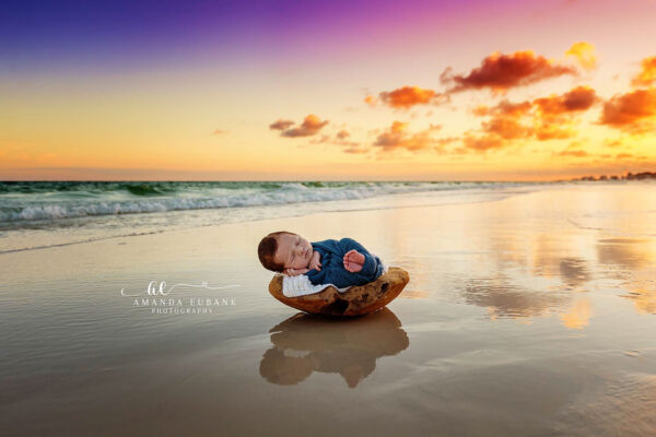 Seaside newborn photographer documents a newborn's first days with a stunning beach portrait at sunset